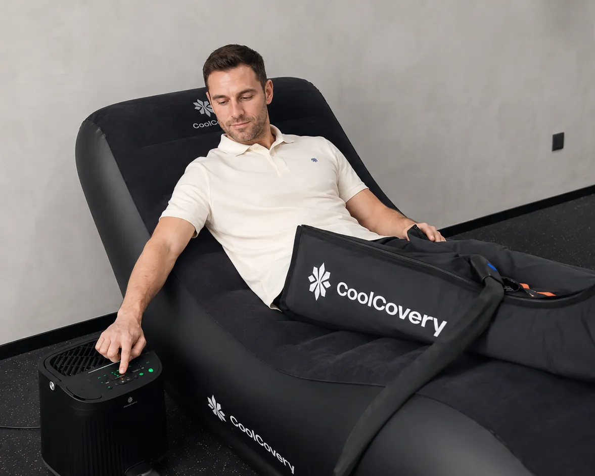 A man recovering on a lounger with the CoolCovery boots and control unit.